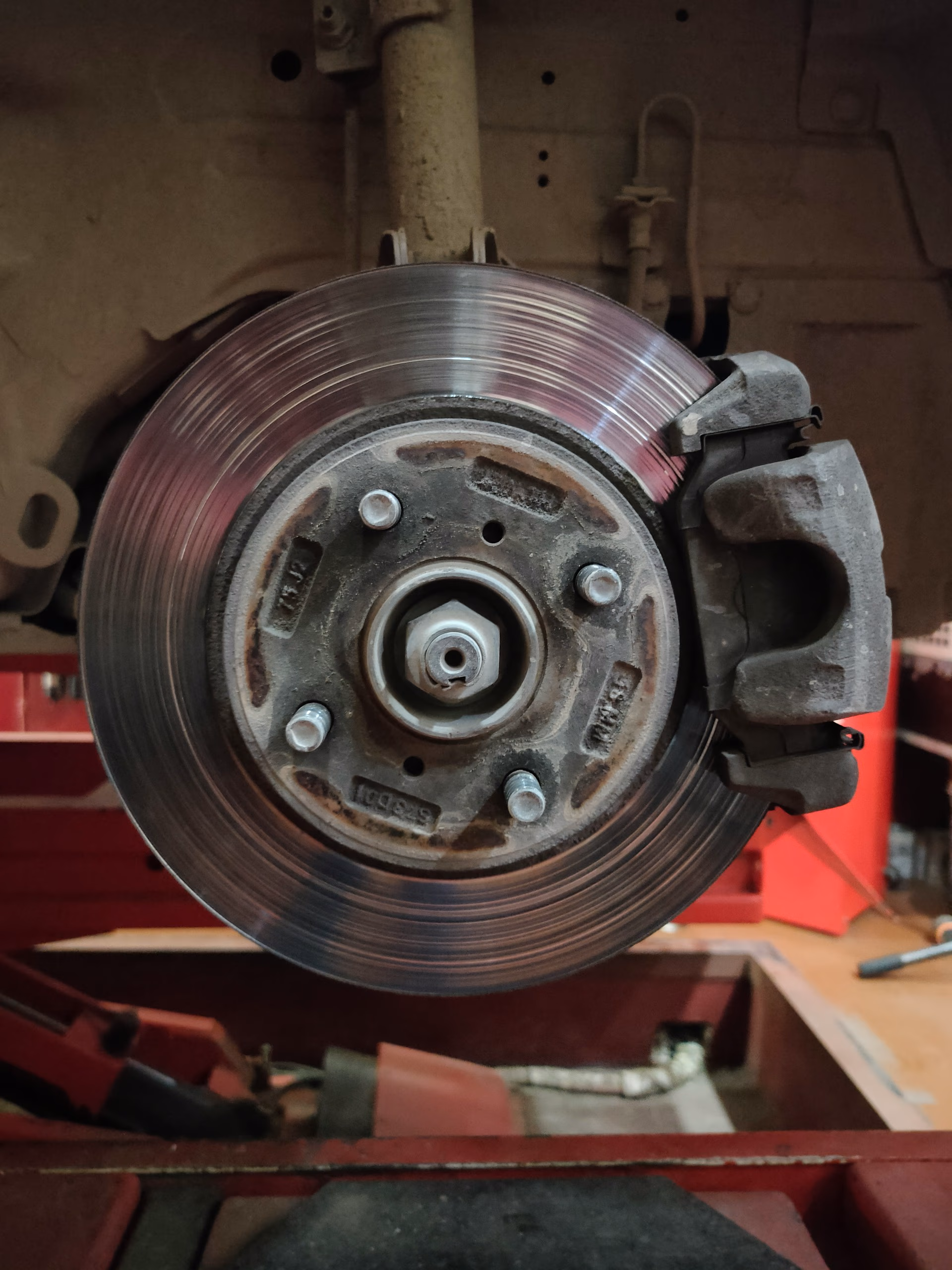 Close-up of a car's brake disc and caliper assembly without the wheel.