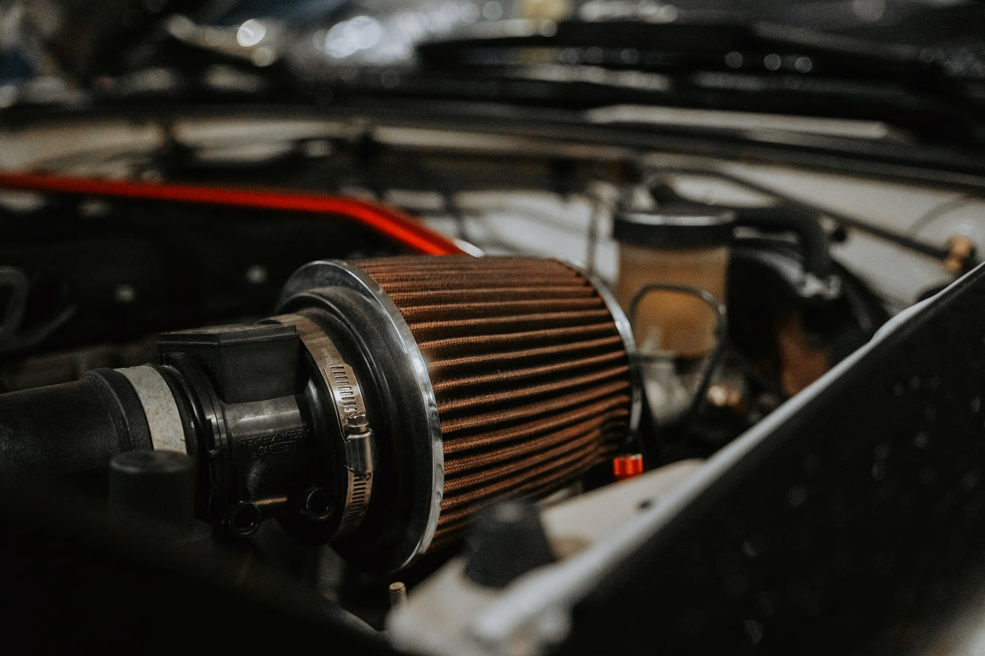 Close-up of a cylindrical air filter installed in a car engine compartment.