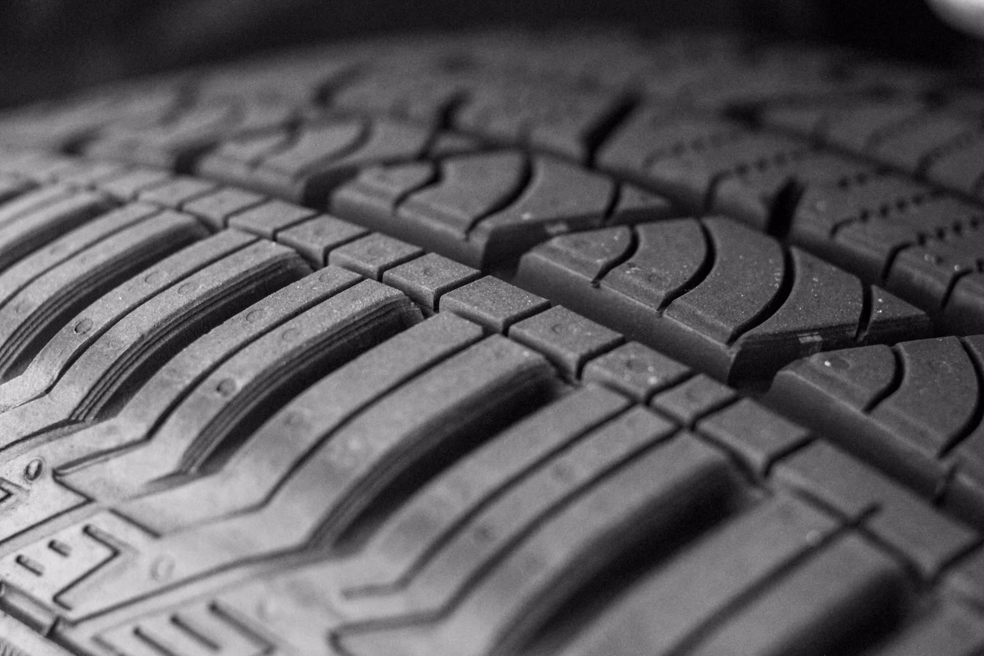 Close-up of a tire tread showing detailed pattern and texture in black and white.